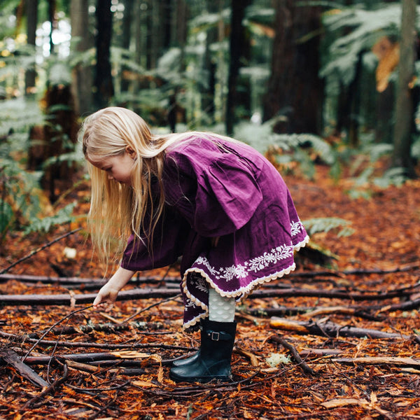 Child wearing Lamington Children's Pistachio Knee High Socks while playing in the bush.