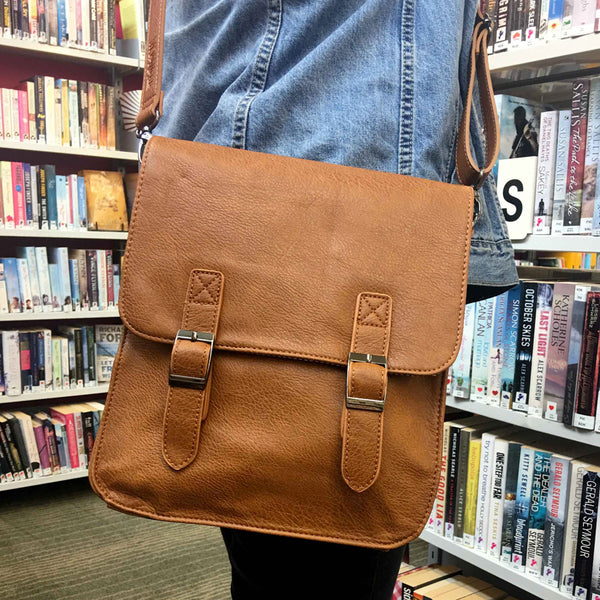 Model in library wearing Tan Moana Road Uni Satchel.