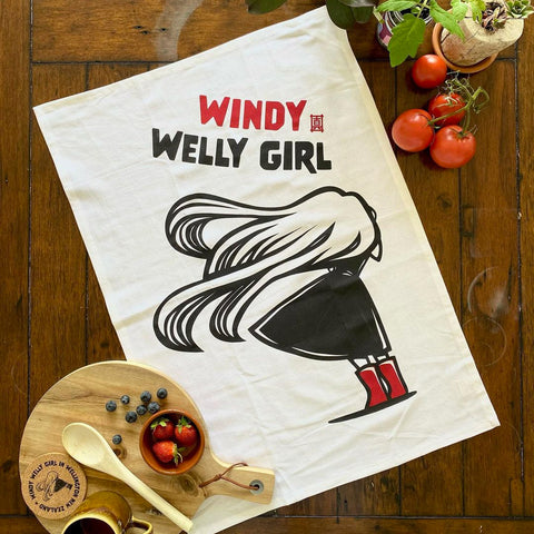 Flatlay image of Masako Styles Windy Welly Girl with Red Boots Tea Towel.